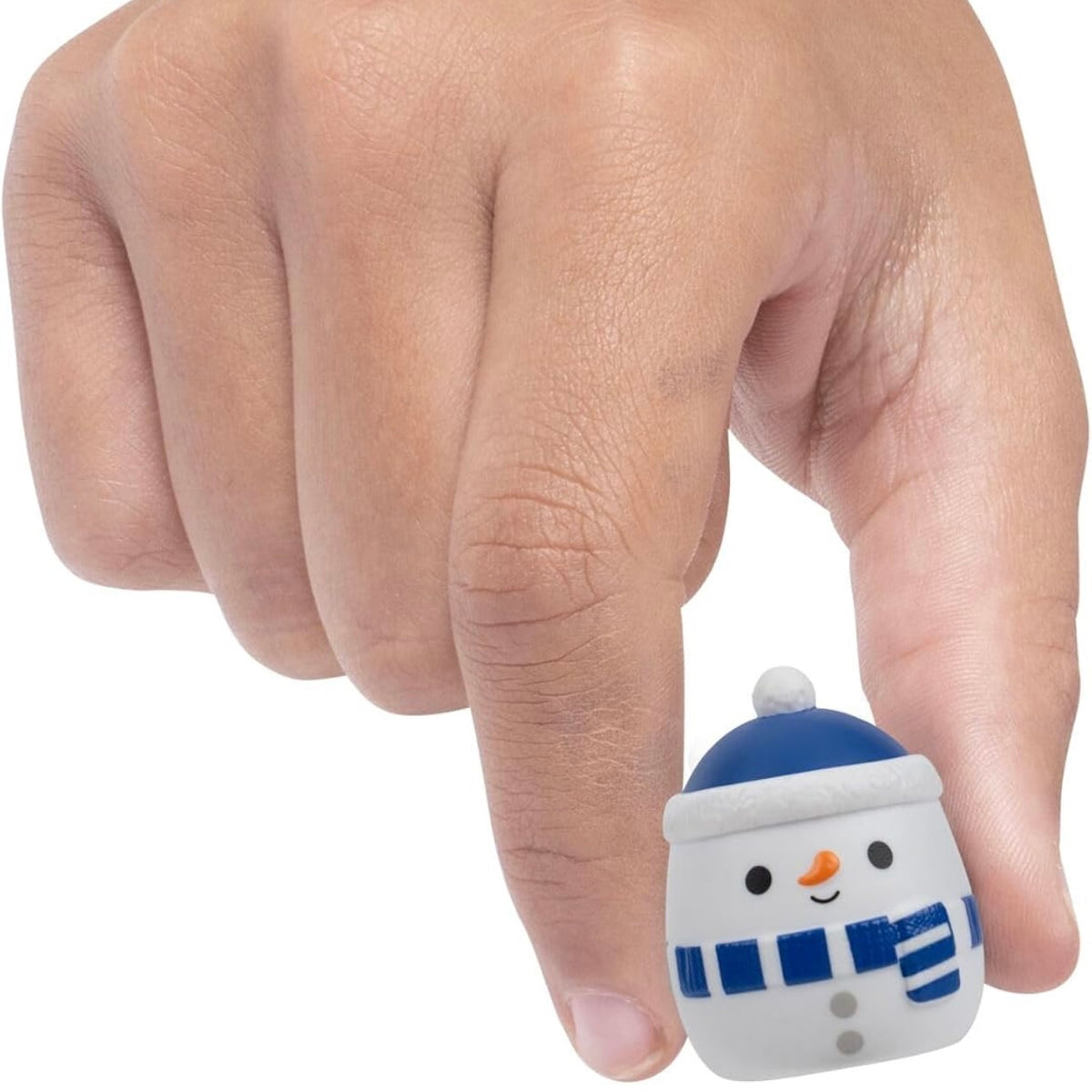 A small snowman figurine being held between a person's fingers against a plain white background.