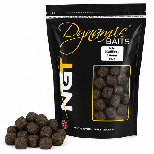 A black stand-up pouch of Dynamic Baits Pellet Halibut 16mm 600g, shown with a small pile of dark brown pelleted bait in front on a white background.